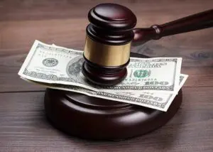 Judge gavel and money on brown wooden table concept